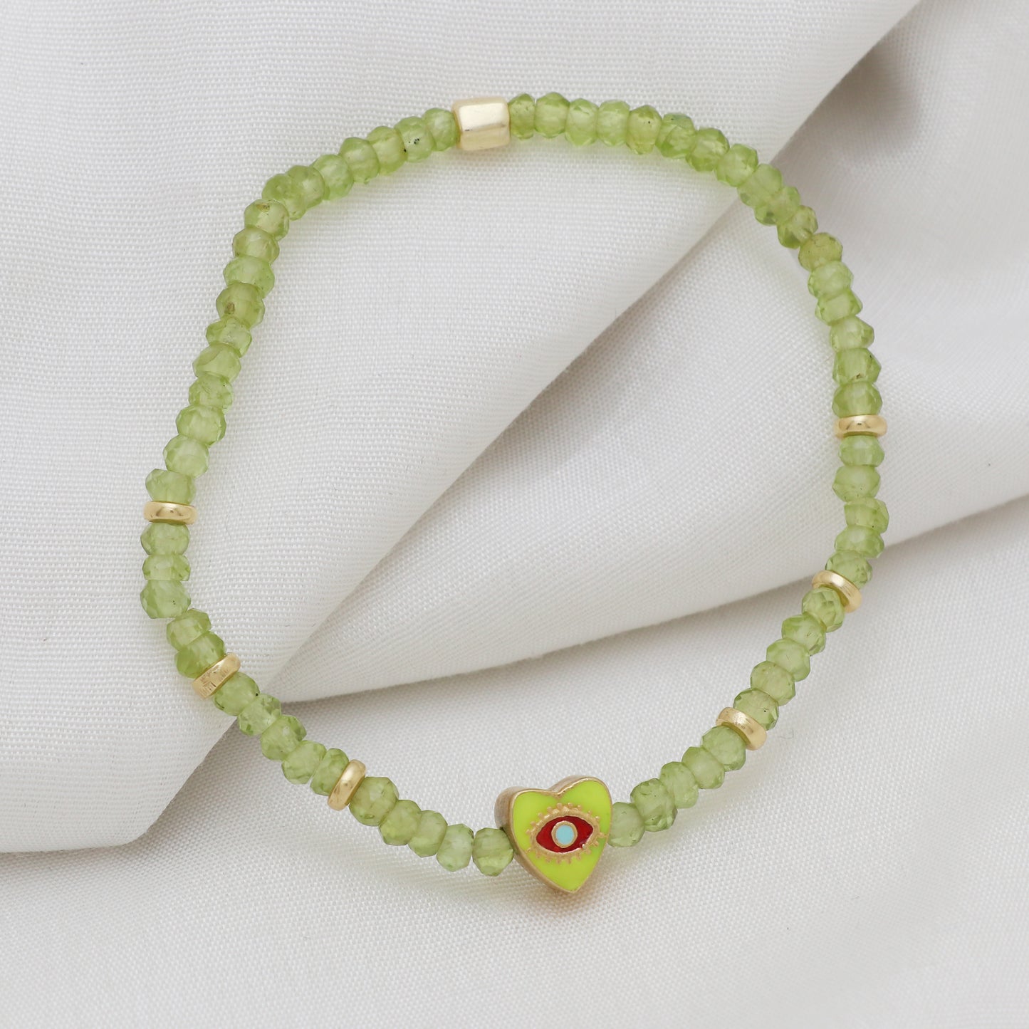 Peridot heart charm with evil eye engraved stretch bracelet with green and red enamel in gold plated 925 sterling silver