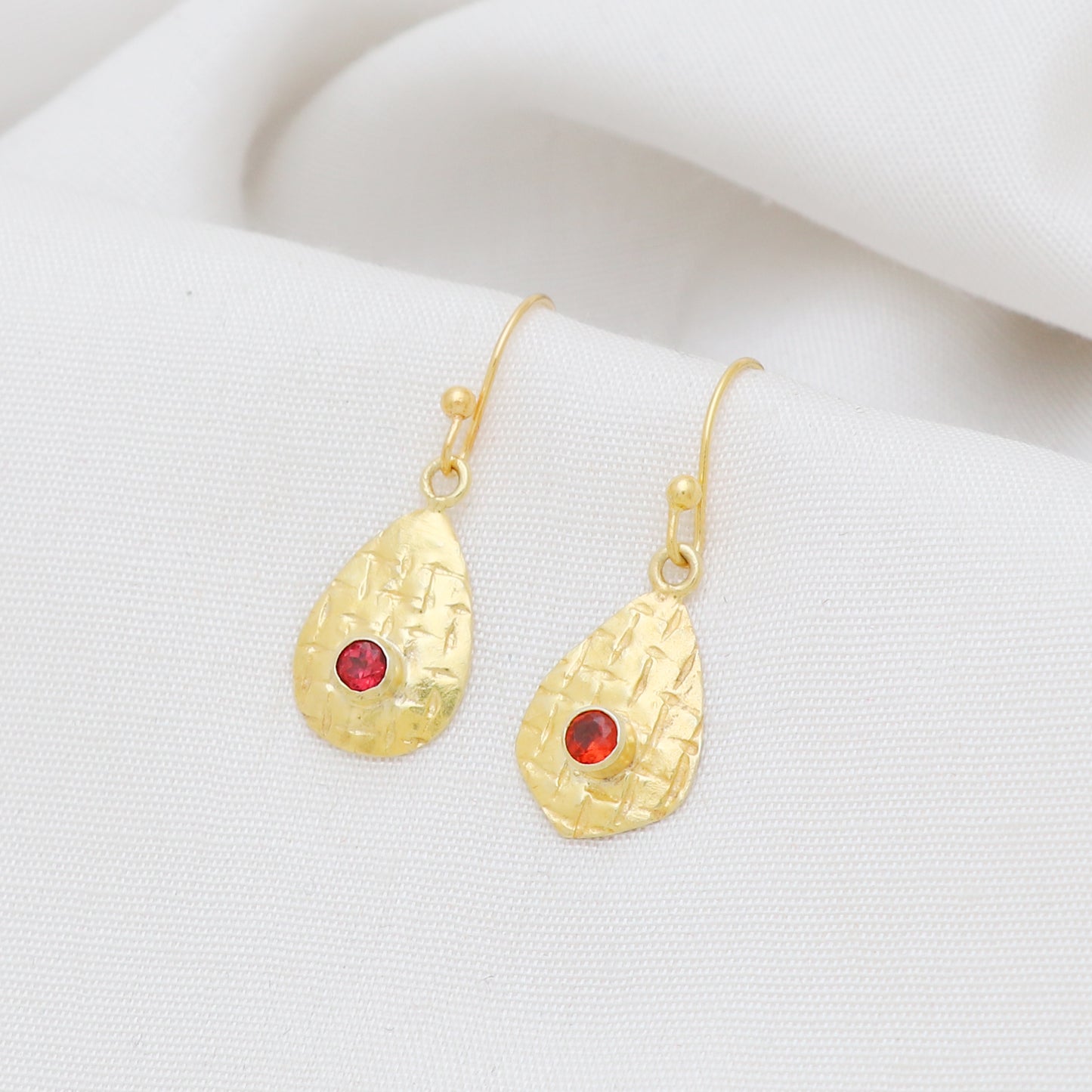 Textured earring with garnet gemstone in gold plated 925 sterling silver