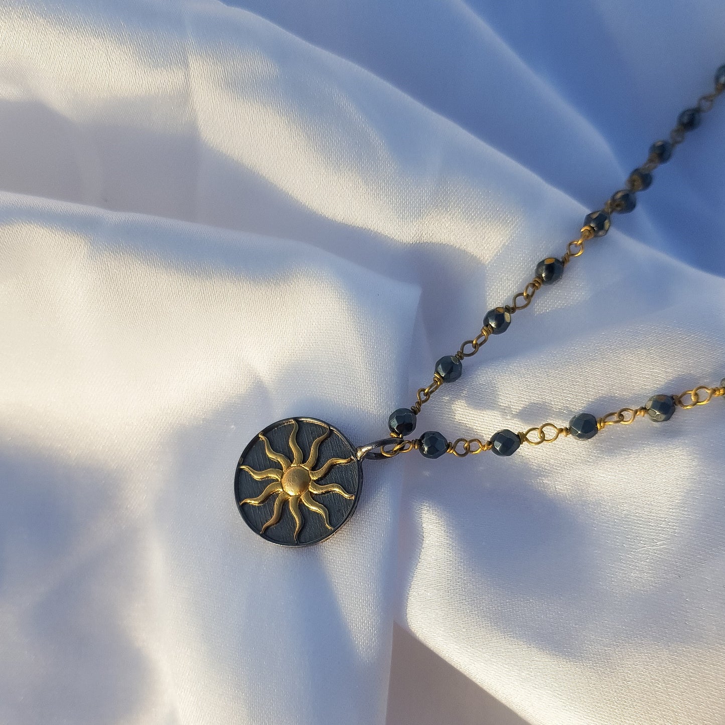 Hematite beaded necklace with Sun charm in two tone black rhodium and 22k gold plated 925 sterling silver
