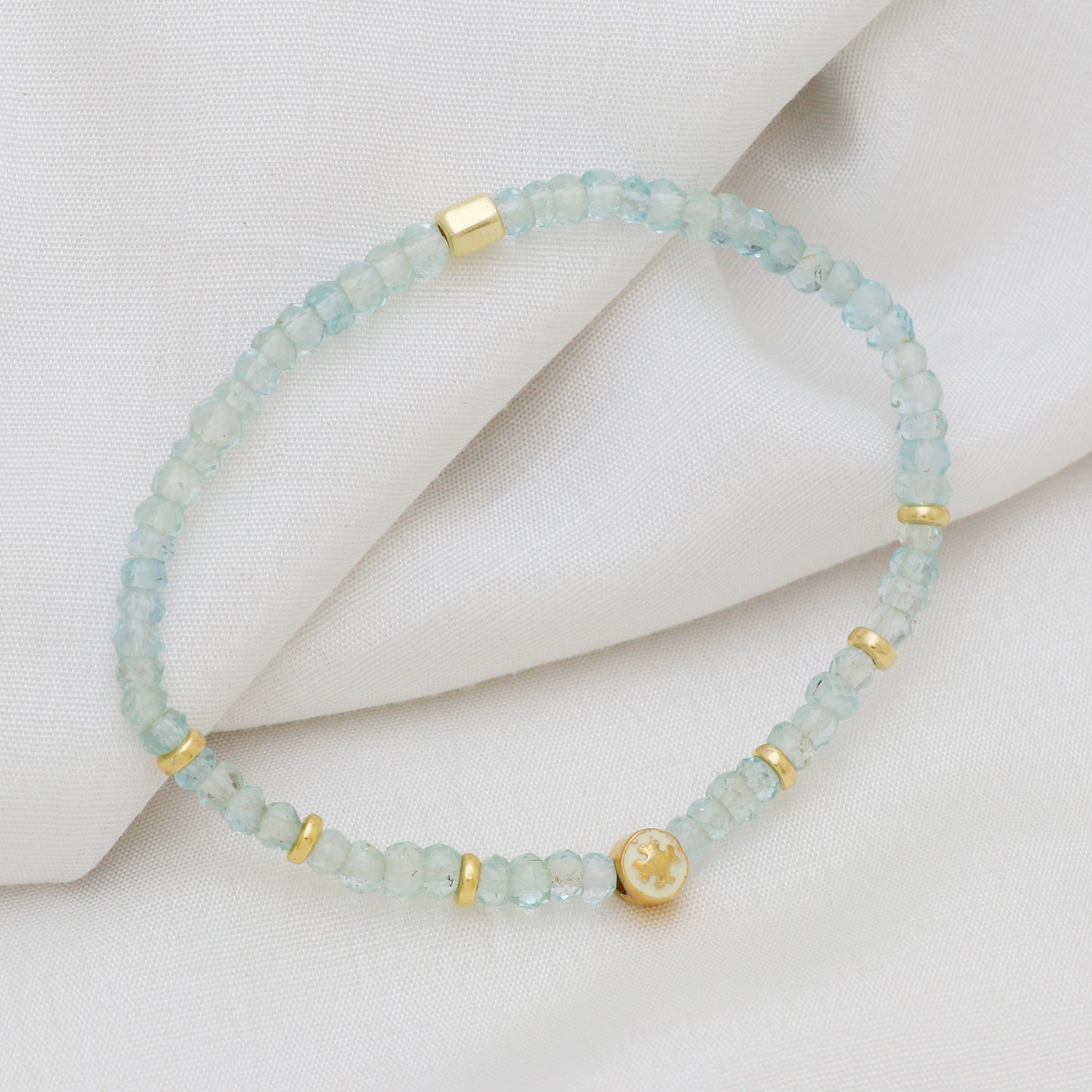 Aquamarine flower charm stretch bracelet with white enamel in gold plated 925 sterling silver