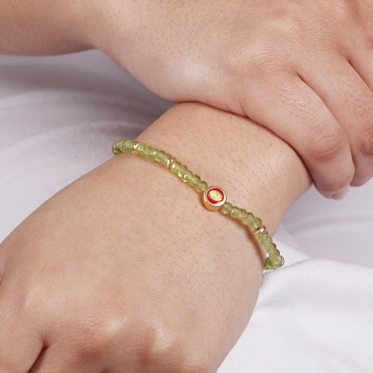 Peridot evil eye charm stretch bracelet with yellow, red and blue enamel in gold plated 925 sterling silver